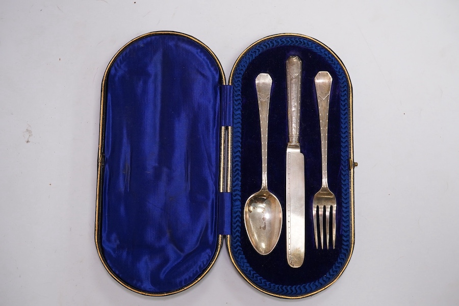 A cased Edwardian silver Christening trio, by Henry Wigful, Sheffield, 1909 and a cased set of eleven Edwardian silver coffee spoons and pair of sugar tongs, London, 1901/2 and one odd silver golf related teaspoon. Condi